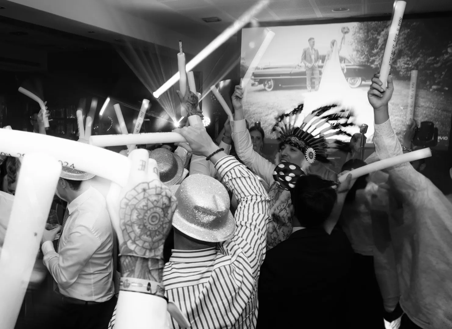 Muchas personas bailando con gorros y porras de espuma en las manos