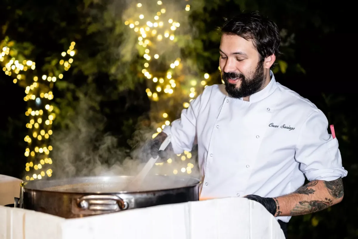 Cocinero removiendo comida en una olla